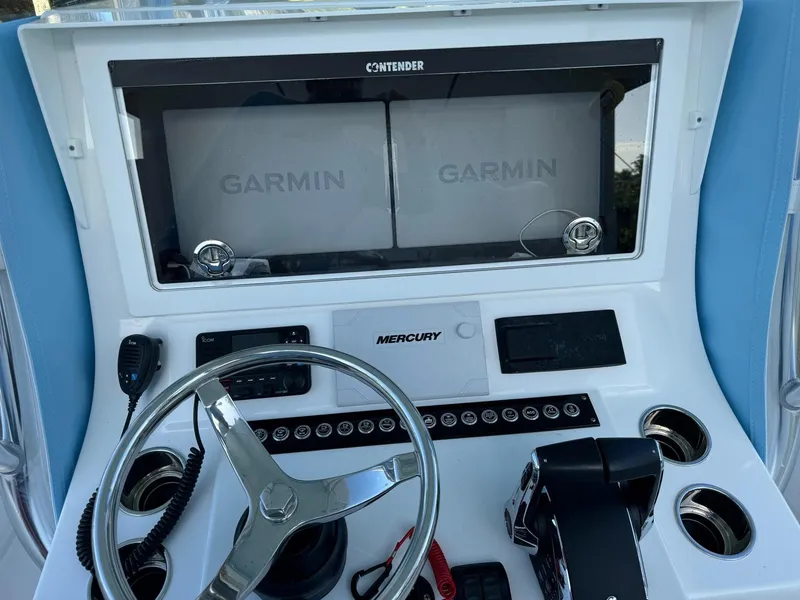 Slide: The Image of 2024 Contender 32 ST boat dashboard with Garmin displays and Mercury controls. - 6