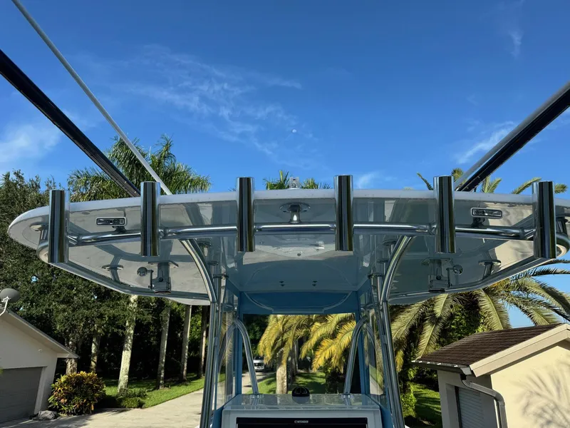 Slide: The Image of 2024 Contender 32 ST boat with rod holders, set against a clear blue sky. - 8