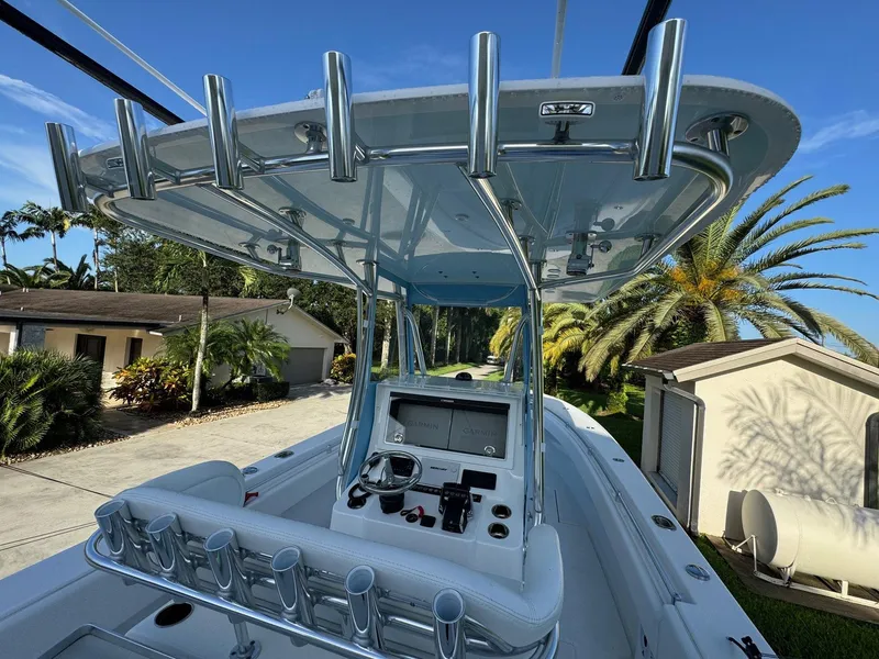 Slide: The Image of 2024 Contender 32 ST boat with sleek console and rod holders, set against a tropical backdrop. - 9