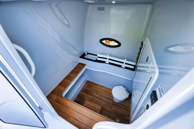 Slide: The Image of 2025 Contender 44 ST boat interior with wooden flooring and compact bathroom amenities. - 16