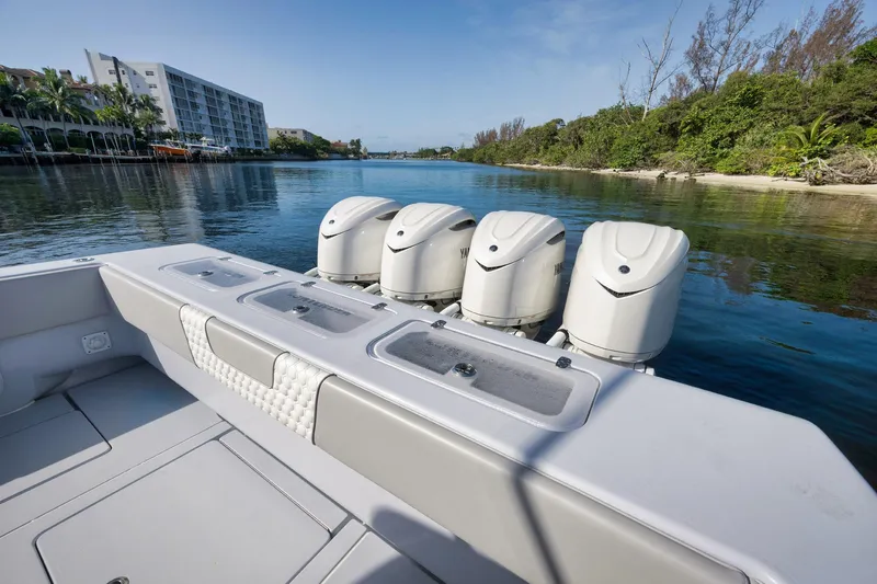 Slide: The Image of 2025 Contender 44 ST boat with powerful outboard engines on a serene waterway. - 40