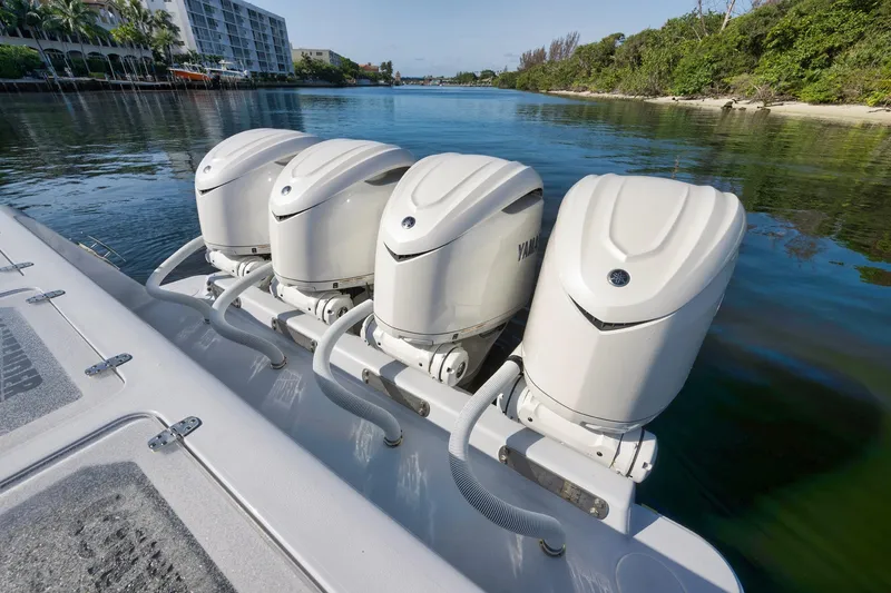 Slide: The Image of 2025 Contender 44 ST boat with four powerful outboard engines on a calm waterway. - 41