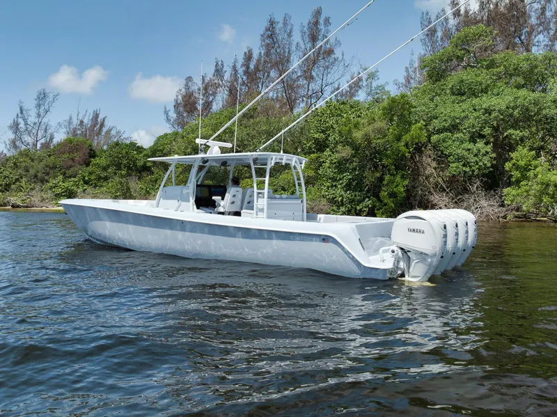 Slide: The Image of 2025 Contender 44 ST boat on water, surrounded by lush greenery. - 46