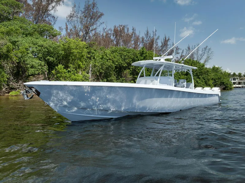 Slide: The Image of 2025 Contender 44 ST boat on calm water, surrounded by lush greenery. - 48