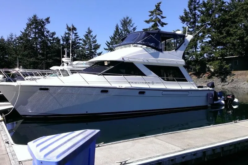Slide: The Image of 1999 Bayliner 3988 Command Bridge Motoryacht on calm water, docked at marina. - 0
