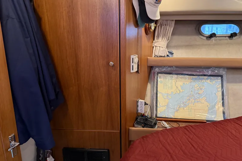 Slide: The Image of 1999 Bayliner 3988 Command Bridge Motoryacht bedroom with red bedding and wooden cabinetry. - 35