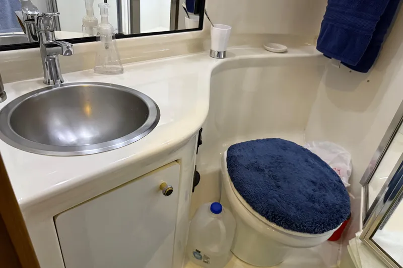 Slide: The Image of 1999 Bayliner 3988 Command Bridge Motoryacht bathroom with wooden accents and blue towels. - 43