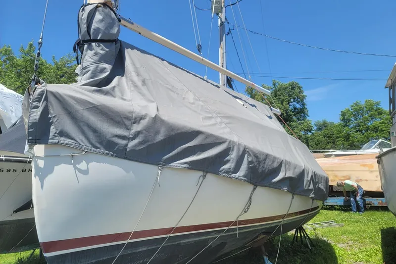 Slide: The Image of 1983 Atlantic City Kitty Kat 21 sailboat covered, stored outdoors on a sunny day. - 12