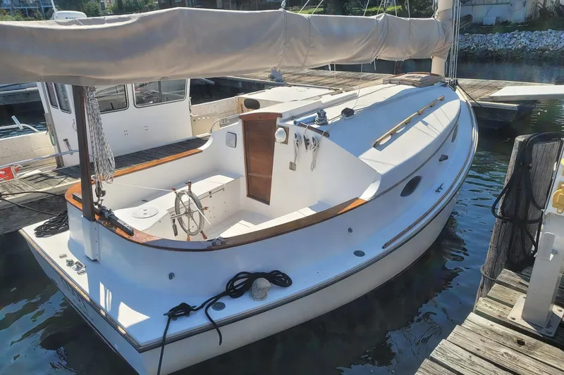 Slide: The Image of 1983 Atlantic City Kitty Kat 21 sailboat docked at marina, featuring wooden accents and white hull. - 3