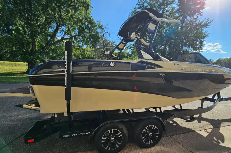 Slide: The Image of 2021 Centurion Fi21 boat on trailer, parked outdoors under clear blue sky. - 4