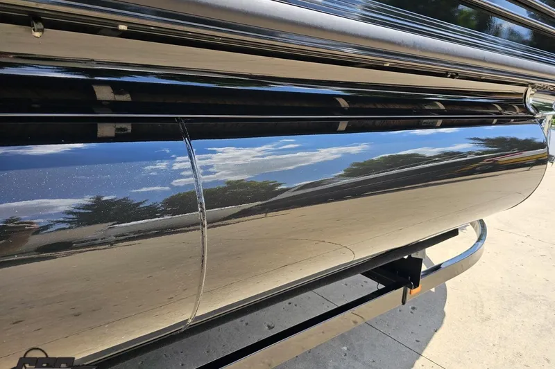 Slide: The Image of Shiny black exterior of 2021 Regency 230 LE3 boat reflecting sky and trees. - 10