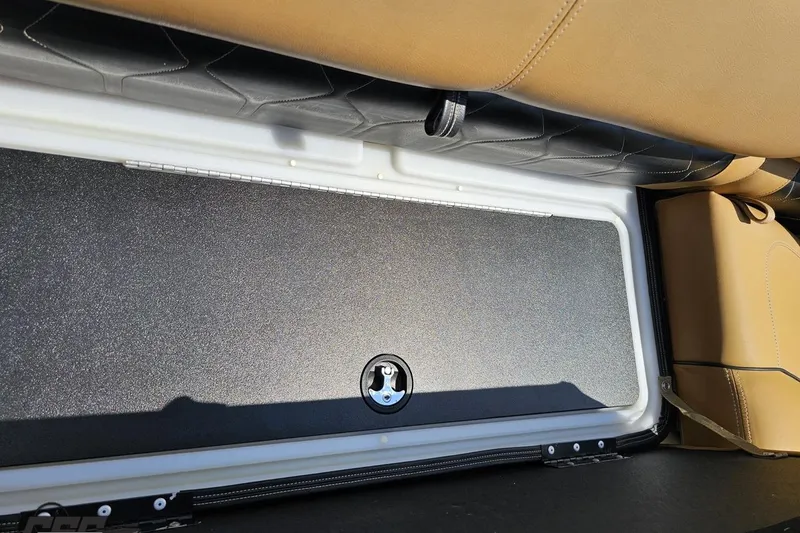 Slide: The Image of Storage compartment in 2021 Regency 230 LE3 boat with tan and black seating. - 105