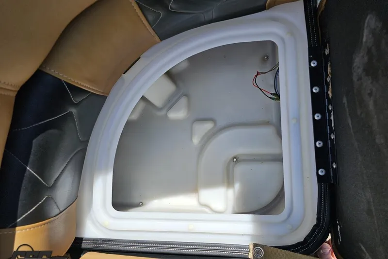 Slide: The Image of 2021 Regency 230 LE3 boat seat storage compartment with wiring visible. - 108