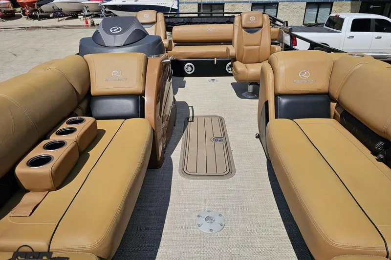 Slide: The Image of 2021 Regency 230 LE3 boat interior with tan leather seating and cup holders. - 112