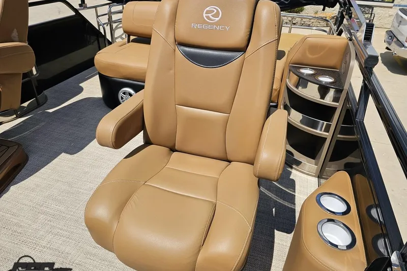 Slide: The Image of Luxurious tan seating on 2021 Regency 230 LE3 boat, featuring cup holders and sleek design. - 115