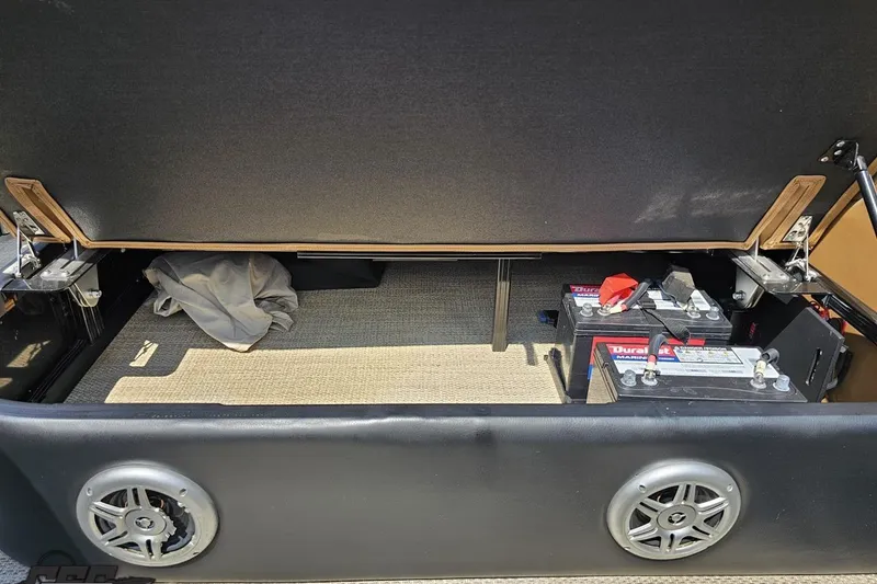 Slide: The Image of Under-seat storage in 2021 Regency 230 LE3 boat, featuring marine batteries and speakers. - 118