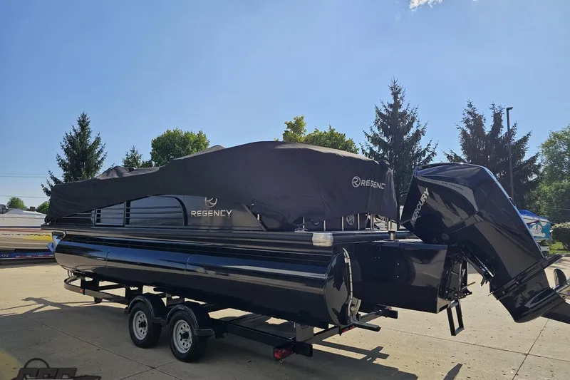 Slide: The Image of 2021 Regency 230 LE3 pontoon boat with cover on trailer, parked outdoors. - 125