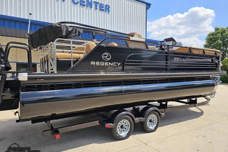 Slide: The Image of 2021 Regency 230 LE3 pontoon boat on trailer outside dealership. - 14
