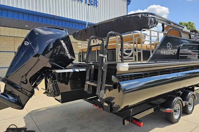 Slide: The Image of 2021 Regency 230 LE3 pontoon boat with Mercury outboard motor, parked on trailer. - 15