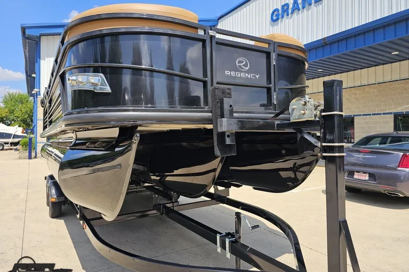 Slide: The Image of 2021 Regency 230 LE3 pontoon boat on trailer outside dealership. - 21