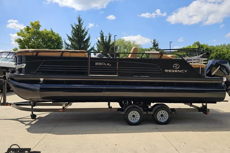 Slide: The Image of 2021 Regency 230 LE3 pontoon boat on trailer, parked outdoors under blue sky. - 29