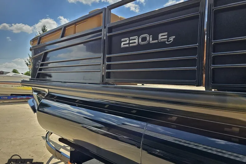 Slide: The Image of 2021 Regency 230 LE3 pontoon boat, sleek black exterior, sunny day background. - 35