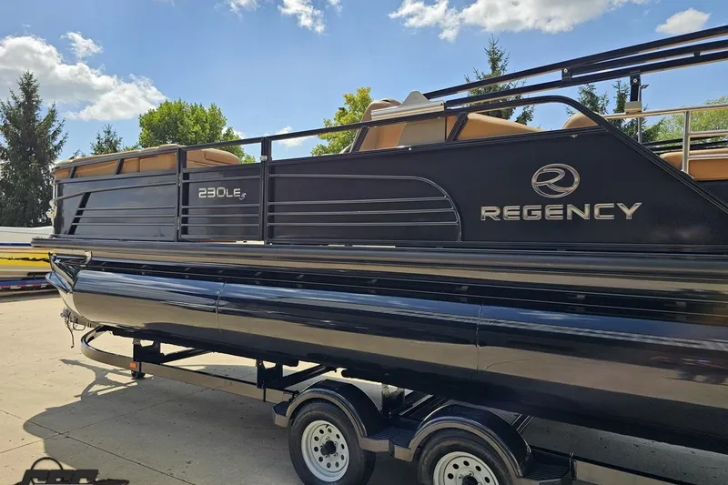 Slide: The Image of 2021 Regency 230 LE3 pontoon boat on trailer under a sunny sky. - 37