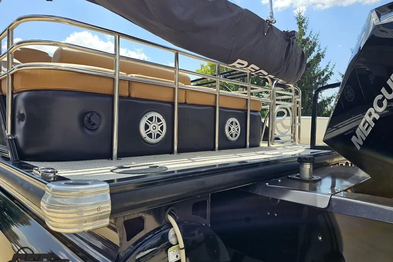Slide: The Image of 2021 Regency 230 LE3 pontoon boat with Mercury engine, featuring tan seating and stainless steel railings. - 41