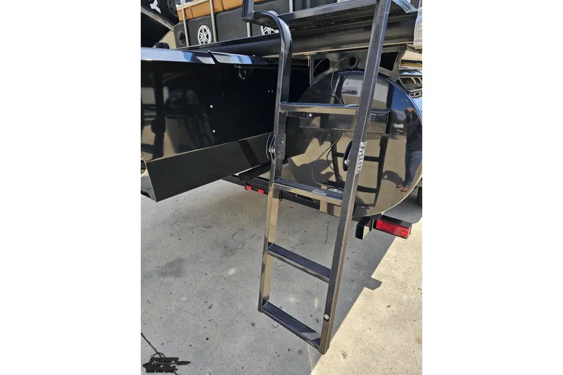 Slide: The Image of Rear view of 2021 Regency 230 LE3 boat ladder and black exterior. - 51