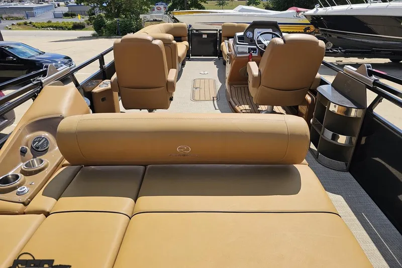 Slide: The Image of 2021 Regency 230 LE3 pontoon boat interior with tan seating and modern dashboard. - 54