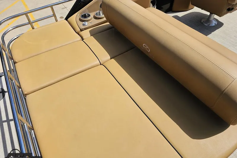 Slide: The Image of Luxurious tan seating on 2021 Regency 230 LE3 boat, featuring cup holders and sleek design. - 55