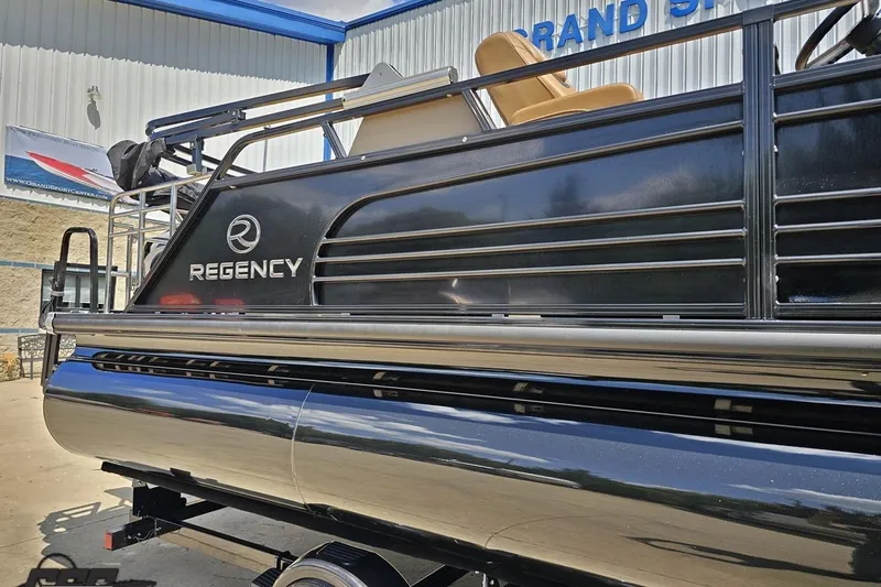 Slide: The Image of 2021 Regency 230 LE3 pontoon boat, black exterior, parked at dealership. - 6