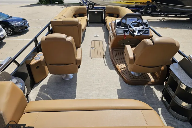 Slide: The Image of 2021 Regency 230 LE3 pontoon boat interior with tan seating and modern dashboard. - 60