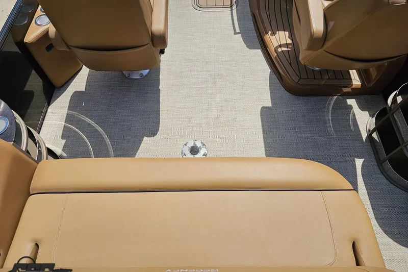 Slide: The Image of Interior of 2021 Regency 230 LE3 boat with tan seating and carpeted flooring. - 61