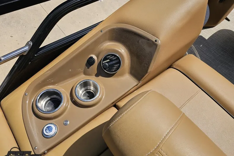 Slide: The Image of 2021 Regency 230 LE3 boat interior with cup holders and audio controls. - 62