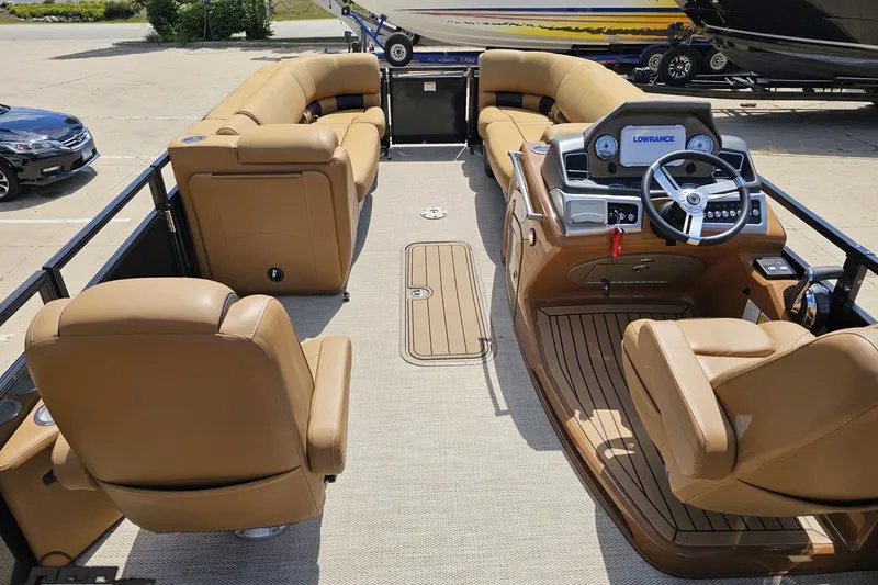 Slide: The Image of 2021 Regency 230 LE3 pontoon boat interior with tan seating and modern dashboard. - 63