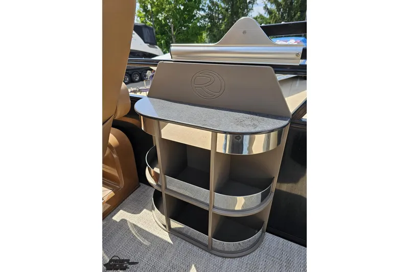 Slide: The Image of 2021 Regency 230 LE3 boat interior storage compartment with shelves and metallic accents. - 64