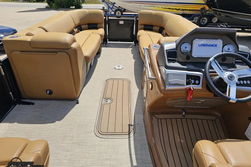 Slide: The Image of Luxurious interior of 2021 Regency 230 LE3 pontoon boat with tan seating and modern dashboard. - 66