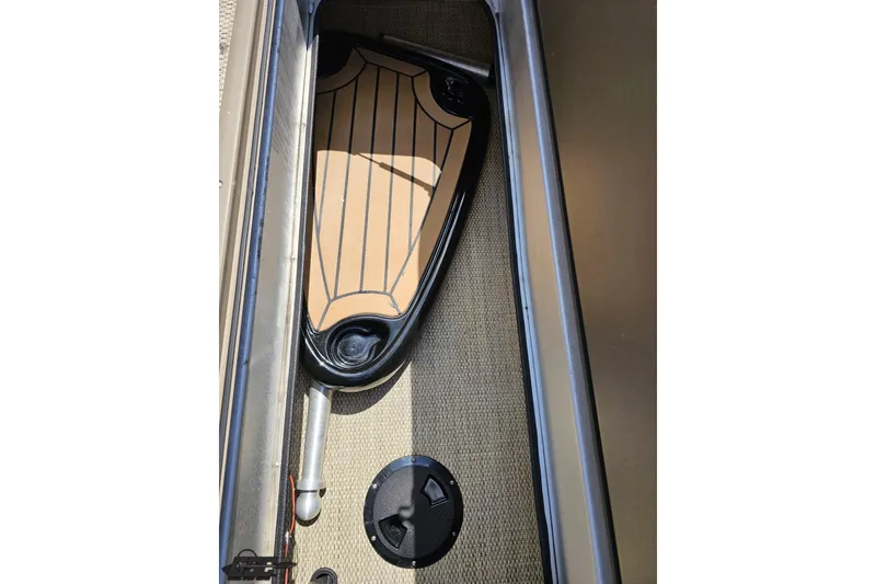 Slide: The Image of 2021 Regency 230 LE3 boat interior storage compartment with paddle and hatch. - 74