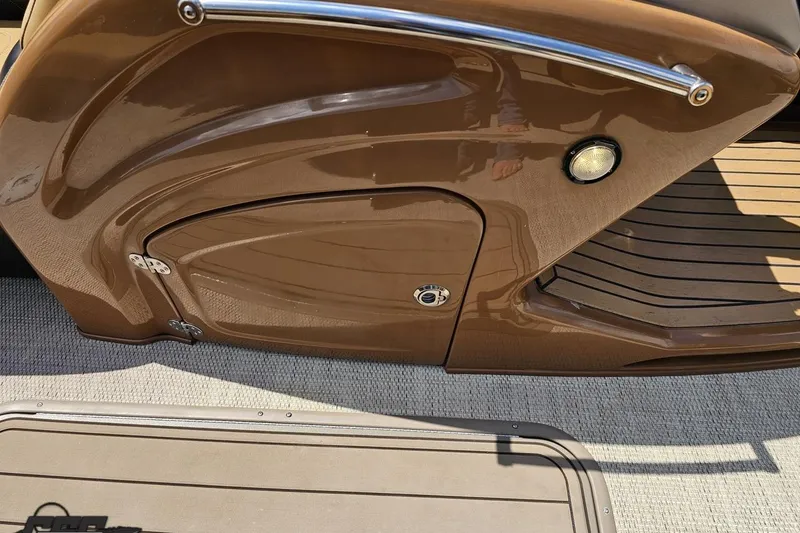 Slide: The Image of 2021 Regency 230 LE3 boat interior detail with brown finish and deck lighting. - 75