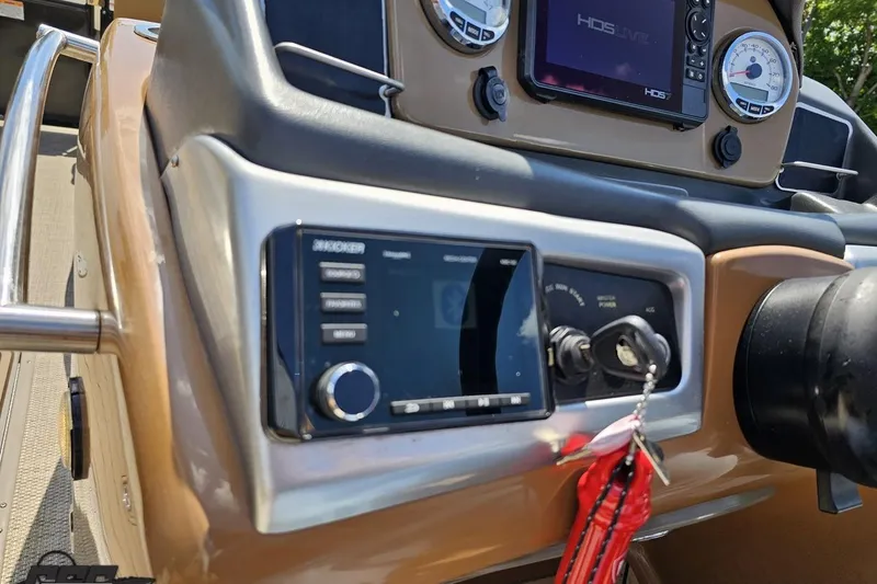 Slide: The Image of 2021 Regency 230 LE3 boat dashboard with controls and display screens. - 82