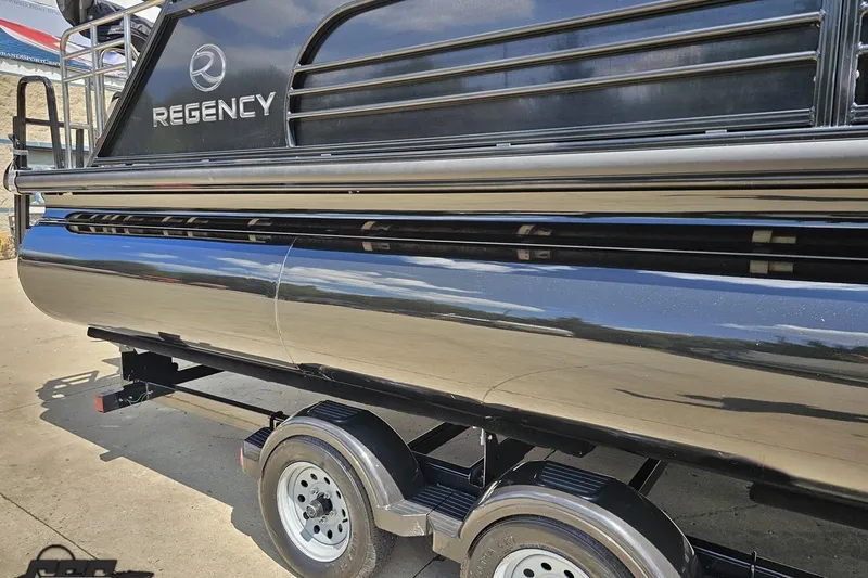 Slide: The Image of 2021 Regency 230 LE3 pontoon boat on trailer, sleek black exterior. - 9
