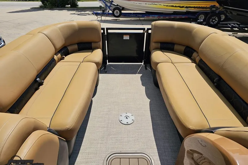 Slide: The Image of 2021 Regency 230 LE3 pontoon boat interior with tan seating and spacious layout. - 90
