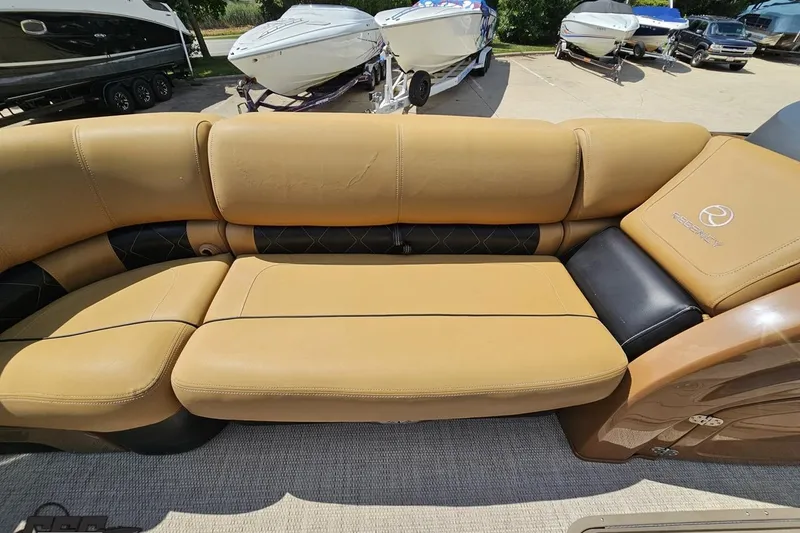 Slide: The Image of Luxurious tan seating on a 2021 Regency 230 LE3 boat, with other boats in the background. - 94
