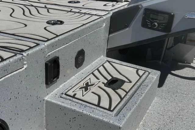 Slide: The Image of 2022 Xpress X19 Pro boat deck with textured surface and storage compartment. - 6