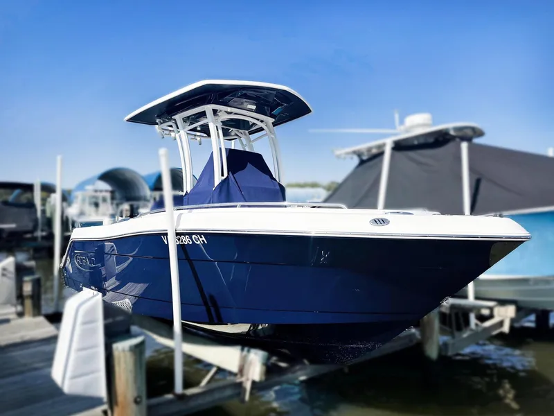 The Image of 2021 Robalo R222 Explorer boat docked, featuring sleek blue design and T-top canopy. - 0