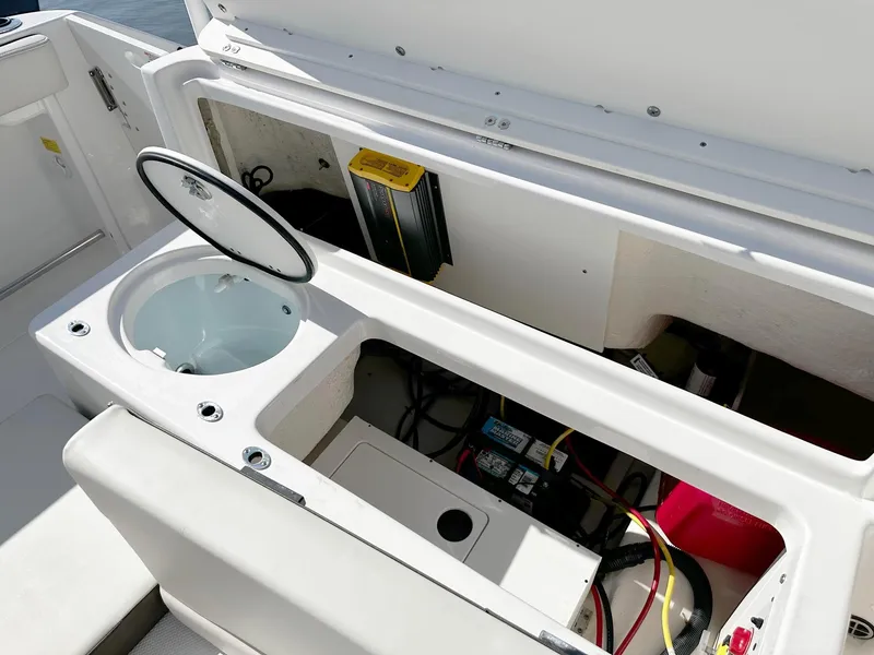 Slide: The Image of 2021 Robalo R222 Explorer boat storage compartment with battery and wiring. - 10