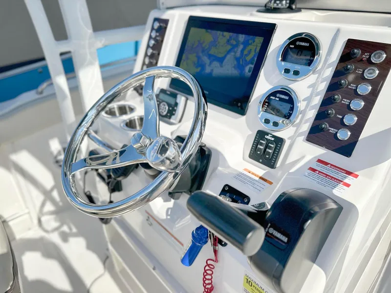 Slide: The Image of 2021 Robalo R222 Explorer boat dashboard with steering wheel and navigation controls. - 21