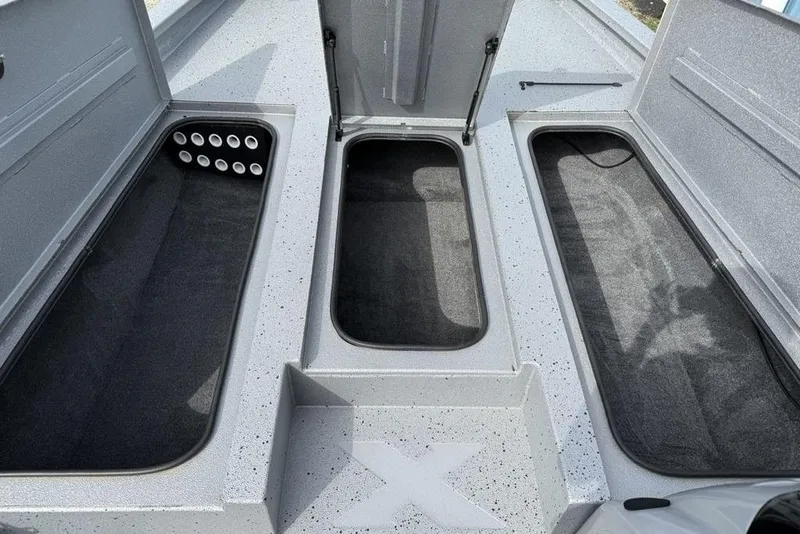 Slide: The Image of 2016 Xpress XCLUSIVE SERIES X21 boat storage compartments with open lids and carpeted interiors. - 7