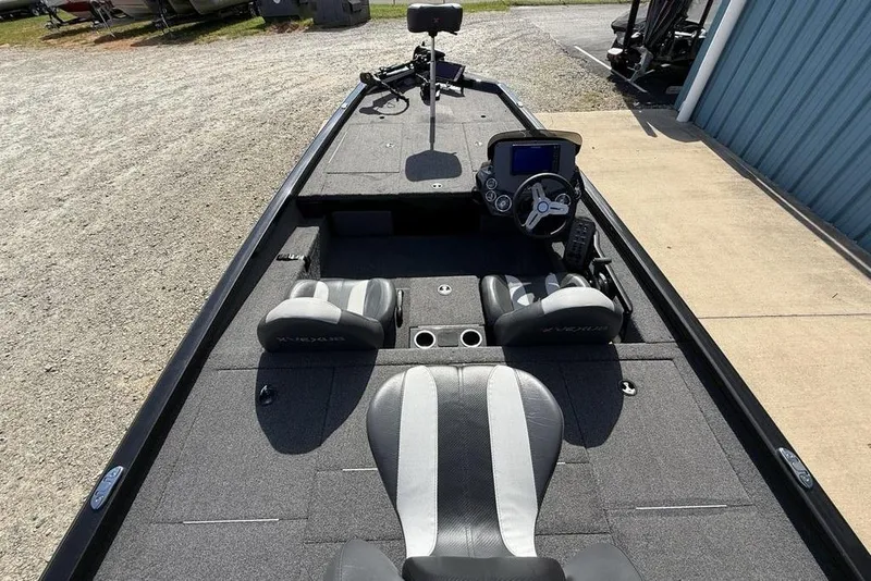 Slide: The Image of 2023 Vexus AVX189 boat interior with steering console and seating, parked on gravel. - 21